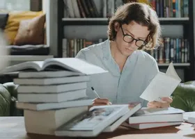 Vai para a biblioteca e começa a fazer algumas de suas tarefas.